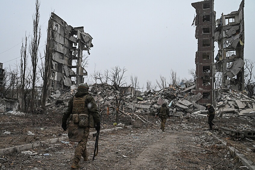 Военнослужащие у разрушенного в ходе боев здания квартала Юбилейный в Авдеевке, февраль 2024 года