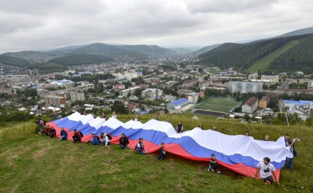 На высочайшей горе Горно-Алтайска развернули 40-метровый российский флаг